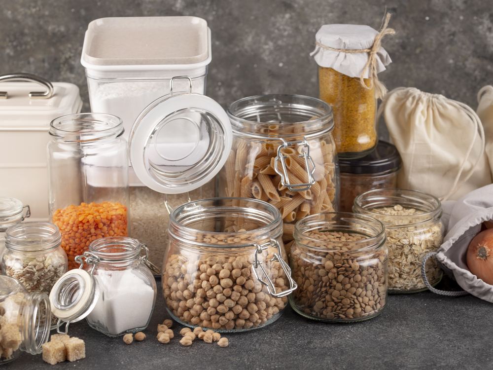 Jars of rice, pasta, lentils, chickpeas and flour arranged together